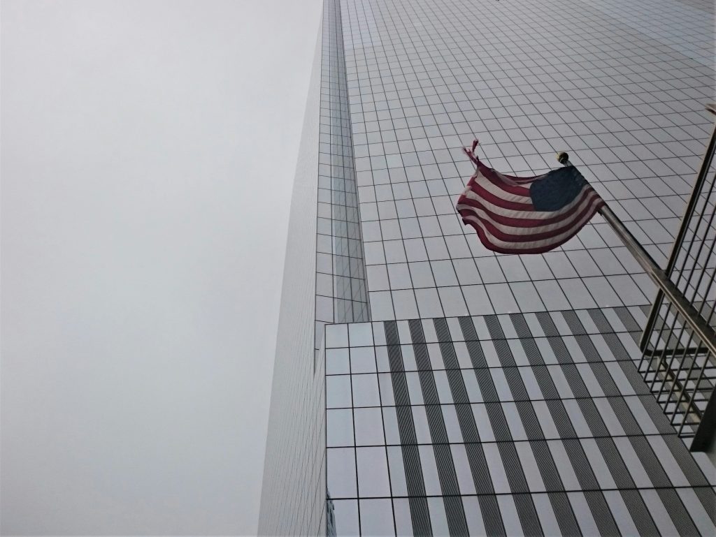 A U.S. flag near a skyscraper.