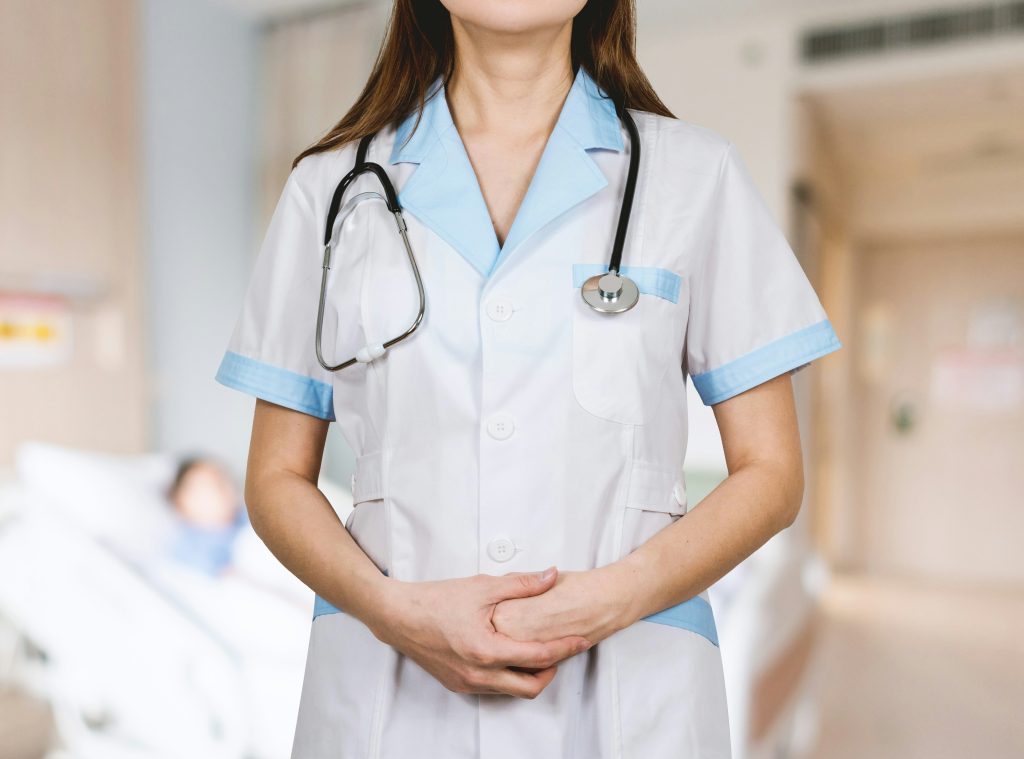 A female doctor is standing upright with her uniform.