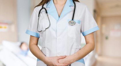 A female doctor is standing upright with her uniform.