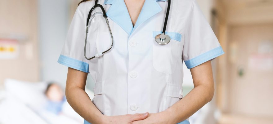 A female doctor is standing upright with her uniform.