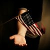 The U.S. flag waves above a person's open palm.