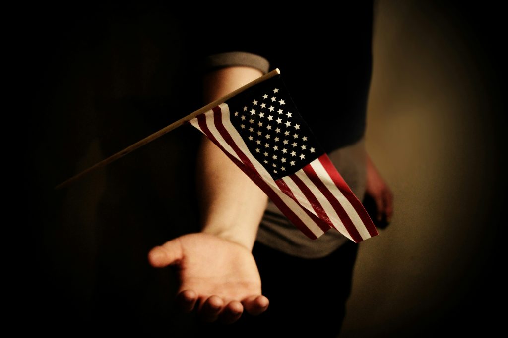 The U.S. flag waves above a person's open palm.