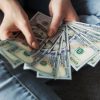 A person holding dollar bills.