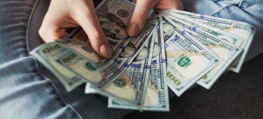 A person holding dollar bills.