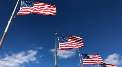 A series of U.S. flags seen from below.