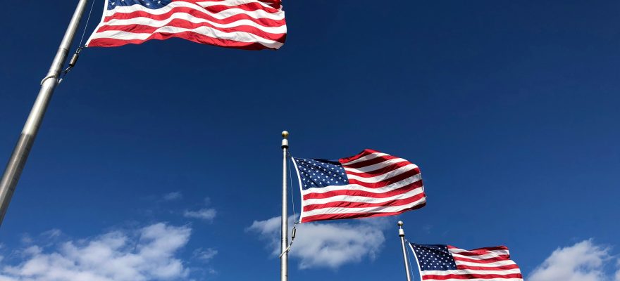 A series of U.S. flags seen from below.
