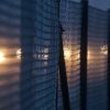 A fence dimly lit at night by a yellow light.