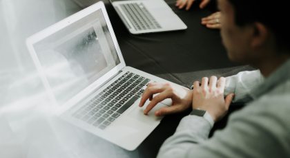 Bir kişi laptop'unu açmış, çalışıyor.