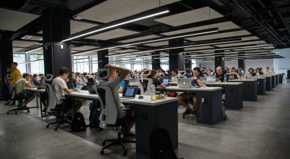 Bir ofis alanında, bilgisayarında çalışan insanlar.