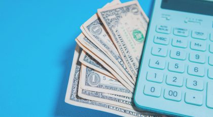 Hesap makinası ve yanında bir miktar Amerikan doları.