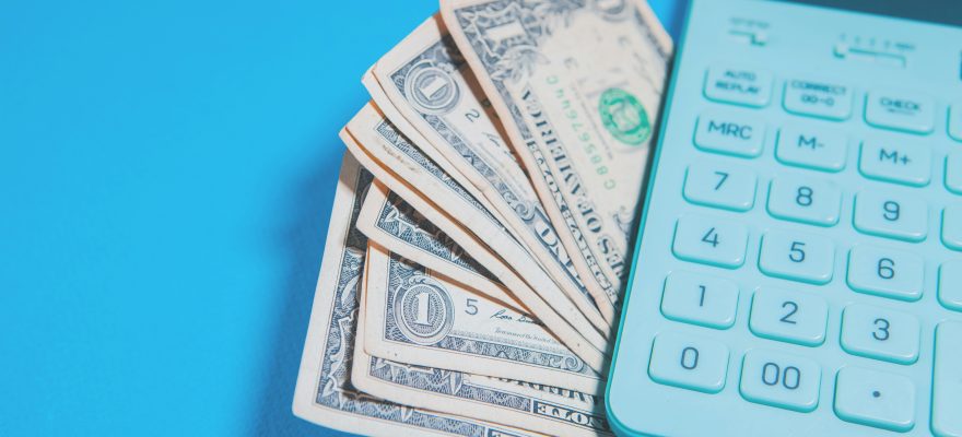 Hesap makinası ve yanında bir miktar Amerikan doları.